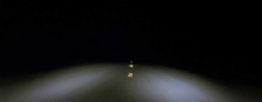 The opening shot of a dark two-lane road in David Lynch's "Lost Highway"